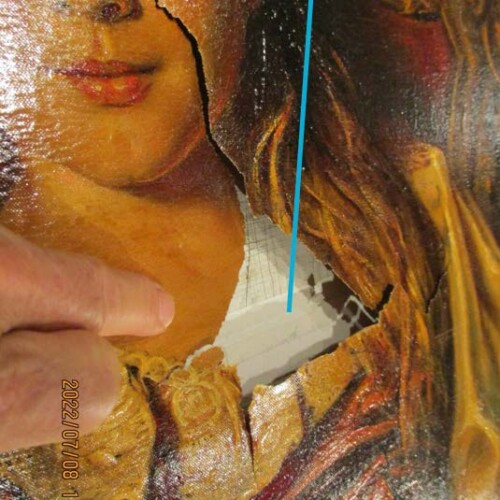A finger pointing at a large tear on a painting of a woman. The painting's canvas is visibly damaged and torn.